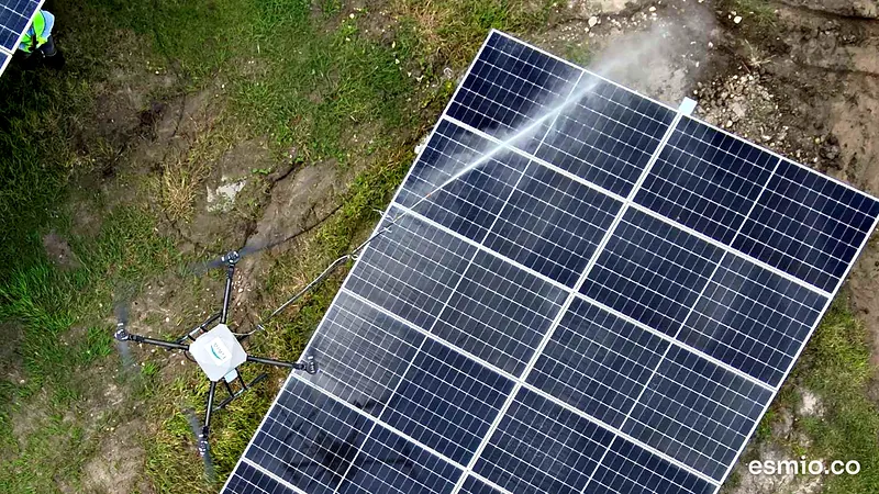 Vista aérea de un panel solar de una granja solar mientras el dron lo lava con agua