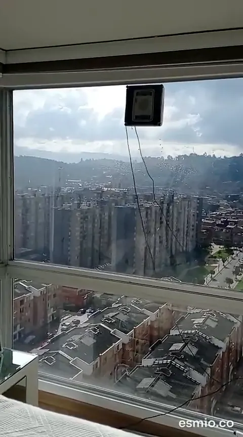 Robot limpiando el ventanal de un apartamento alto