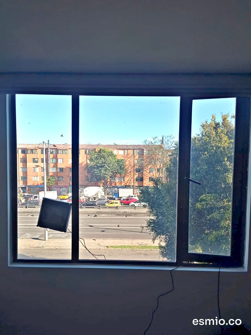 Robot limpia vidrios limpiando la cara exterior de una ventana mientras el operario trabaja desde adentro