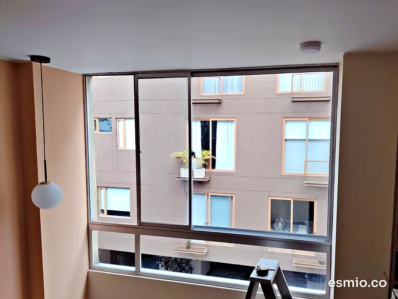 Ventana de apartamento con vista a un edificio de ladrillo, lista para la limpieza con robot
