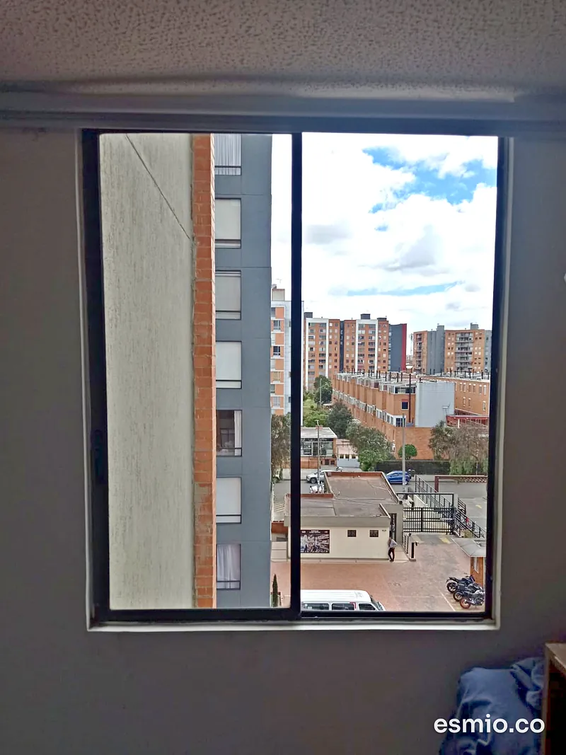 Ventana corrediza con vidrios limpios y vista a conjuntos residenciales de Bogotá