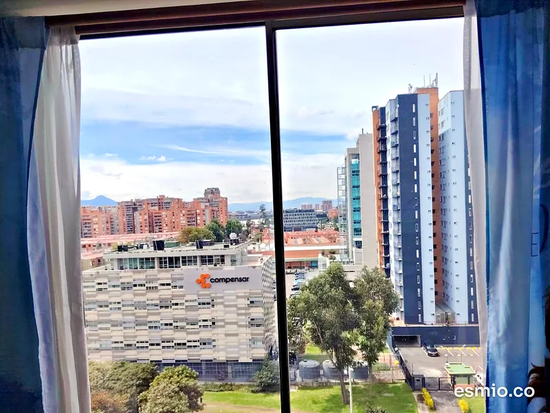 Ventana corrediza con vidrios impecables y vista a un parque de Bogotá