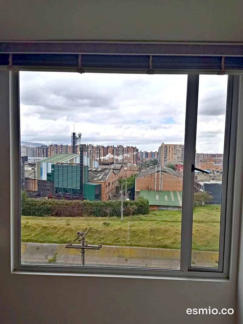 Ventana con vidrios limpios y vista a una zona verde del occidente de Bogotá